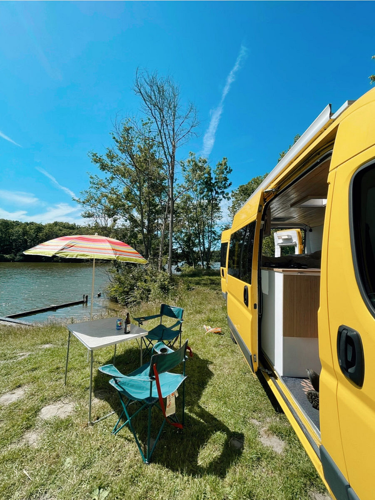 Camper van travel setup by a lake